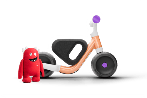 woom WOW Laufrad in pop peach mit Buddy Plüschfigur – Seitenansicht
