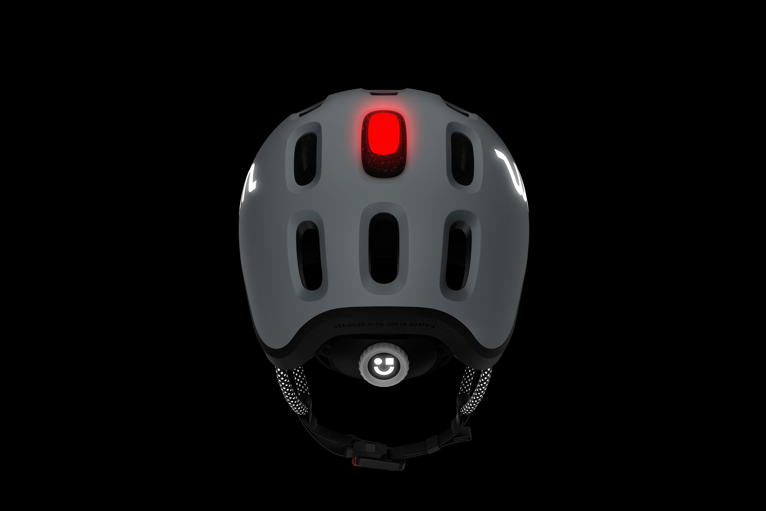 Rear view of the READY Kids' Helmet with the red LED rear light in the top ventilation hole in the dark
