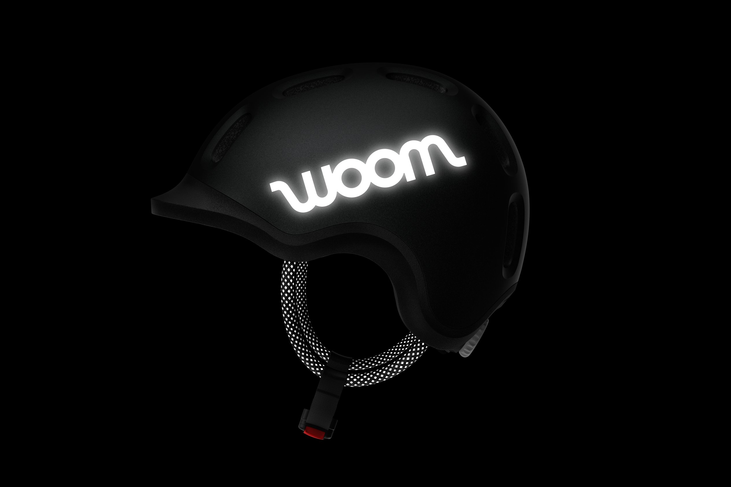 Side view of the READY Kids' Helmet with the reflective woom logos and straps in the dark