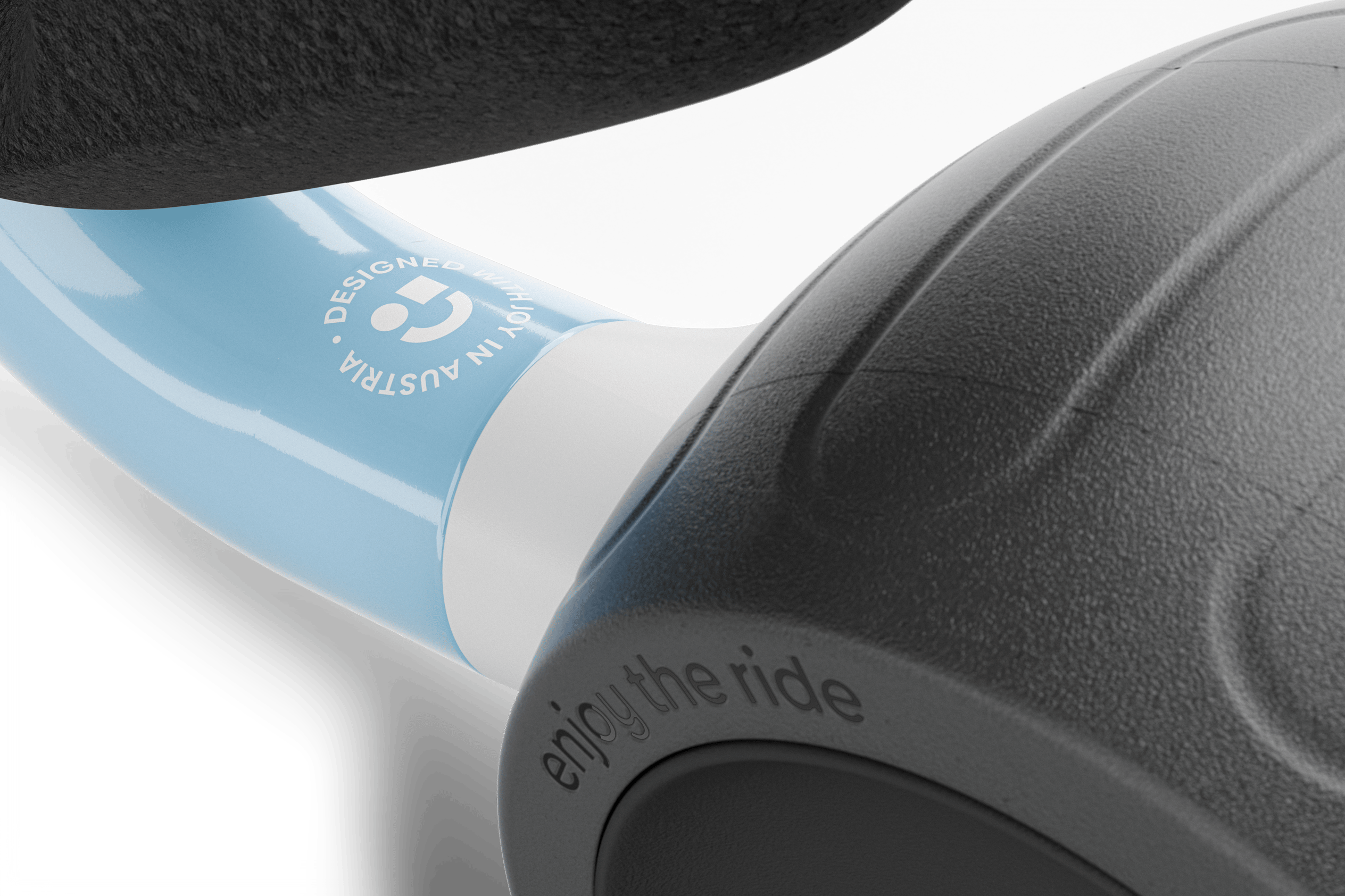 Zoom sur le cadre de la draisienne woom WOW avec l’inscription « Designed with joy in Austria ». 