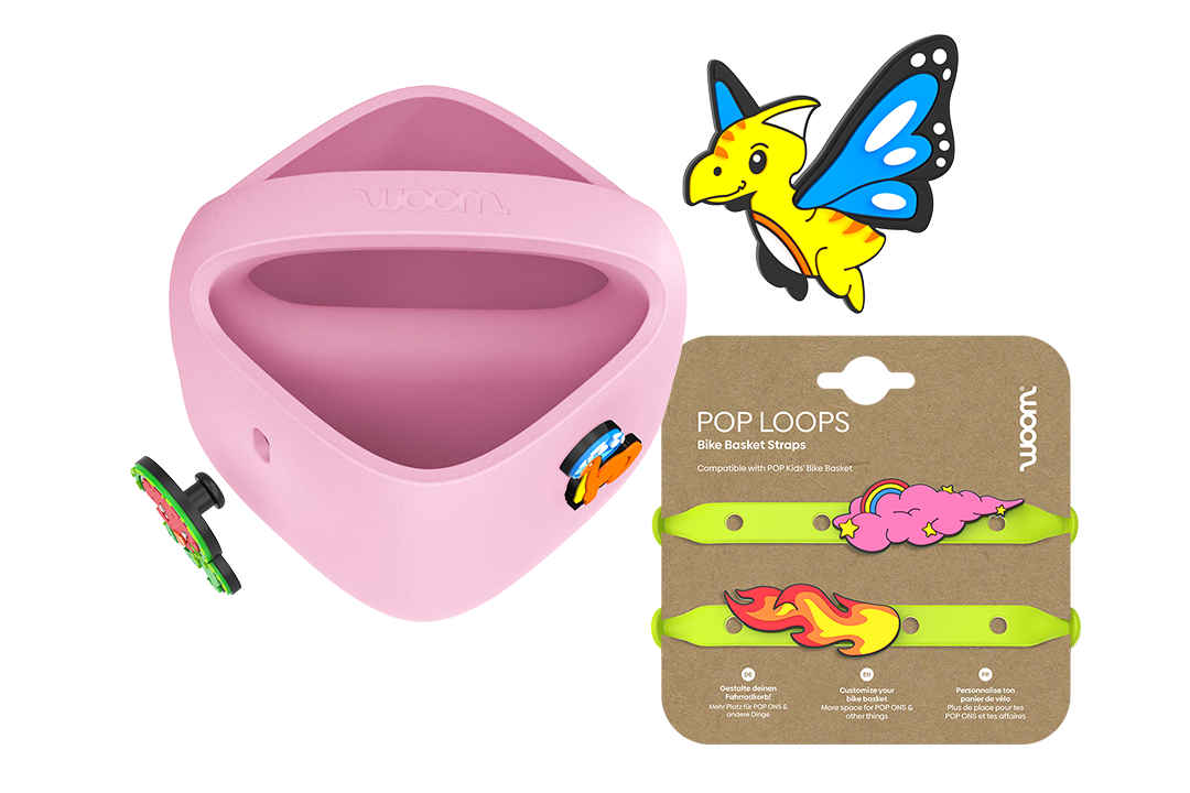 Lilla woom POP cykelkurv med POP ONS ved siden af neongrønne POP LOOPS på pap og en ny POP ON dinosaurus