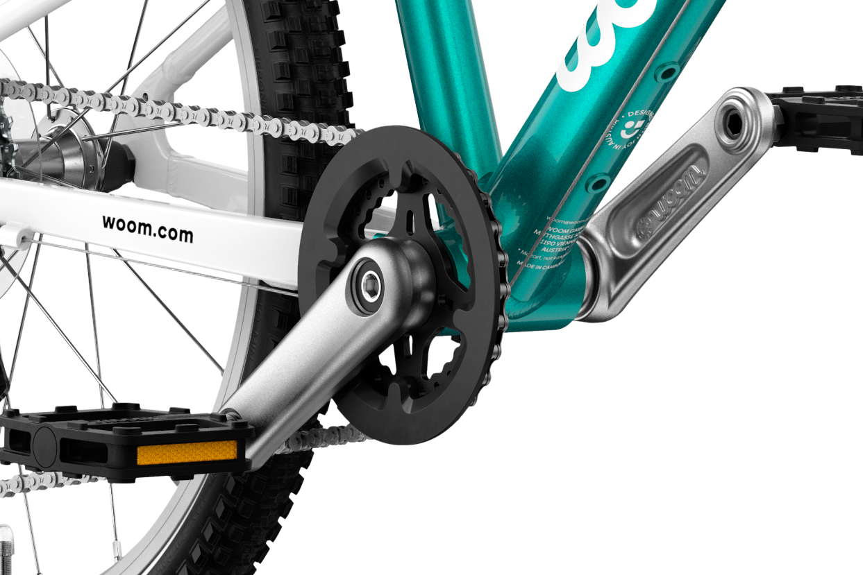 Detailed view of the cranks and pedals on the woom GO 4 children's bike